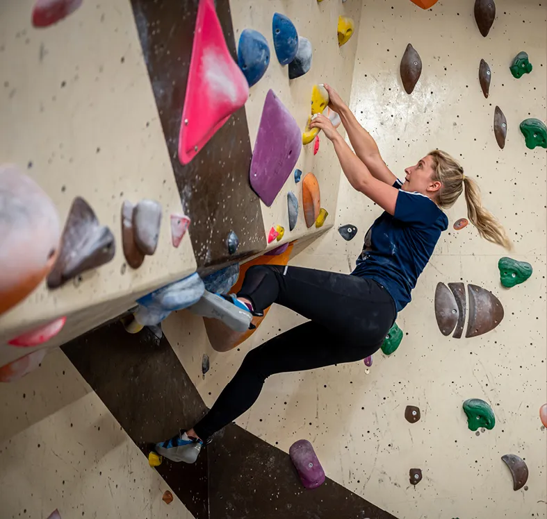 female climber in action on the bouldering wall
